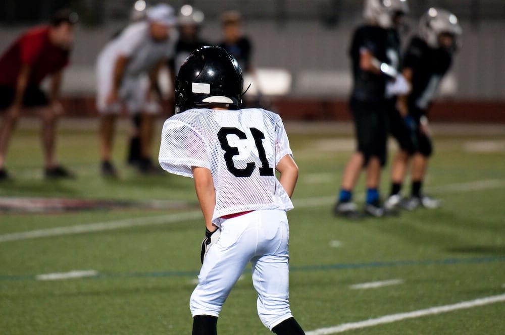 Child in football uniform on field